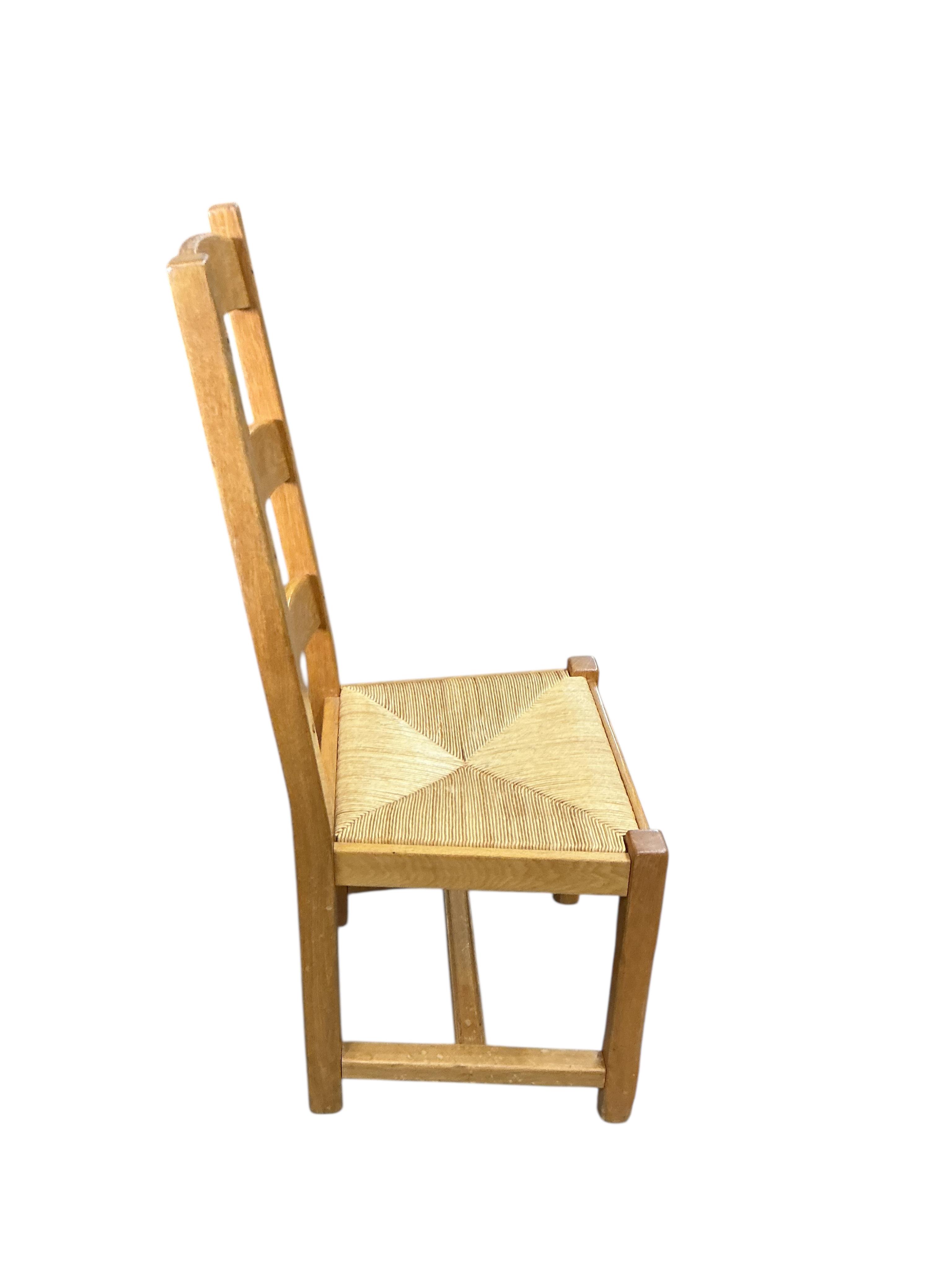 A set of eight contemporary oak rush seat ladderback dining chairs